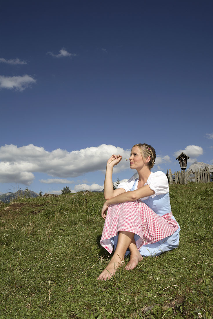 Junge Frau im Dirndl auf einer Almwiese | NIKKY MAIER photo - 06