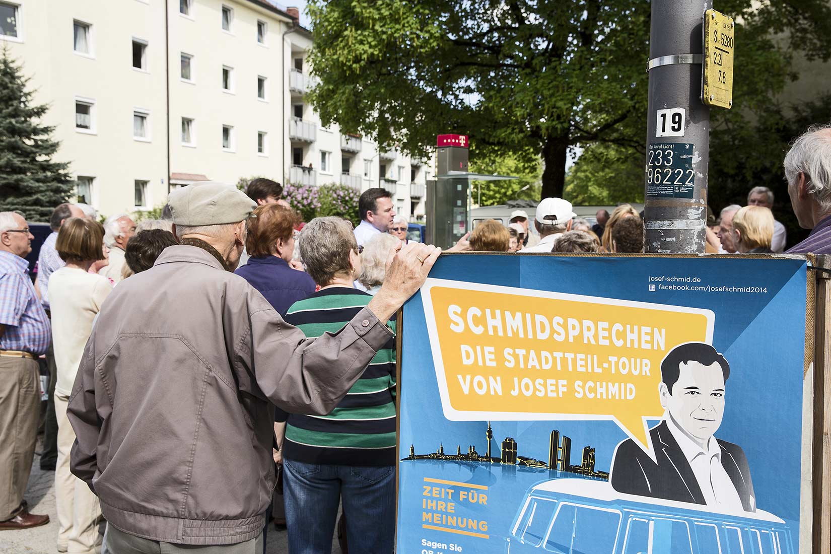 Schmidsprechen Plakat und Josef Schmid umringt von interessierten Bürgern | NIKKY MAIER photo - 04