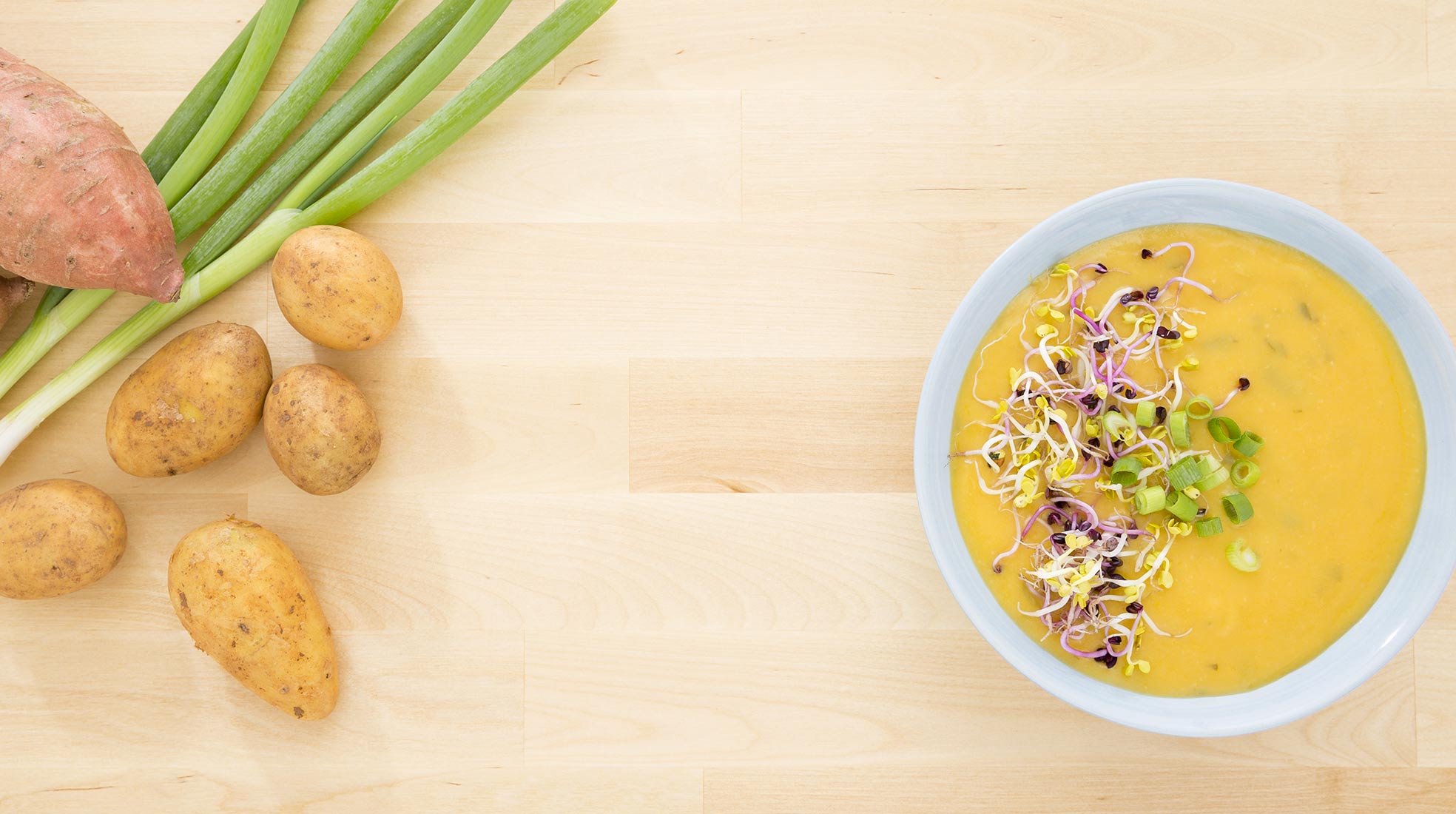 Bio Kartoffelsuppe mit Sprossen angerichtet. Kartoffeln und Frühlingszwiebeln sind die Zutaten | NIKKYMAIER photo - 03