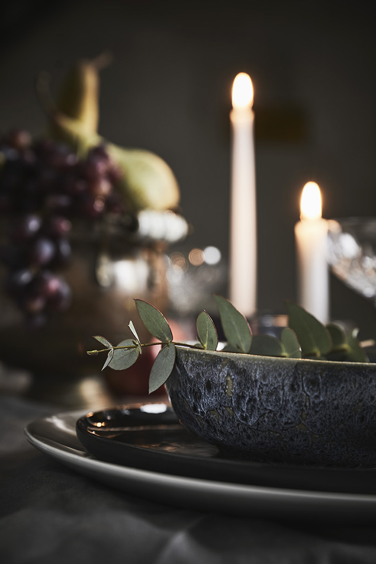 Detail vom Steingut Schälchen mit Eukalyptuszweig, Kerzen und Obst im Hintergrund | NIKKY MAIER photo - 04