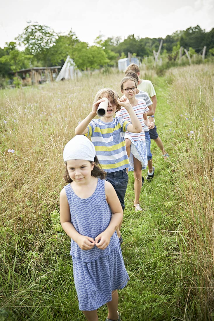 Mehrere Kinder spielen auf einer Wiese der Youfarm Augsburg - NIKKYMAIER photo - 06