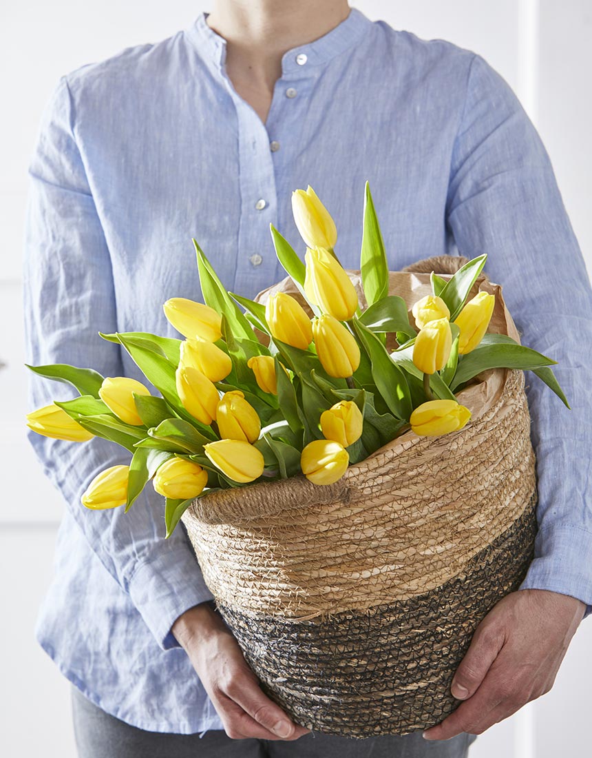 Frau mit einem Korb voller gelber Tulpen | NIKKY MAIER photo - 02